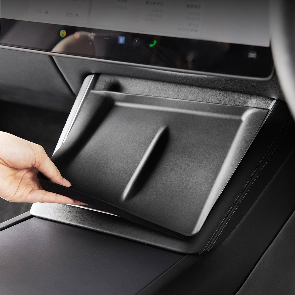 Hand opening a Model Y console tray with a screen above it